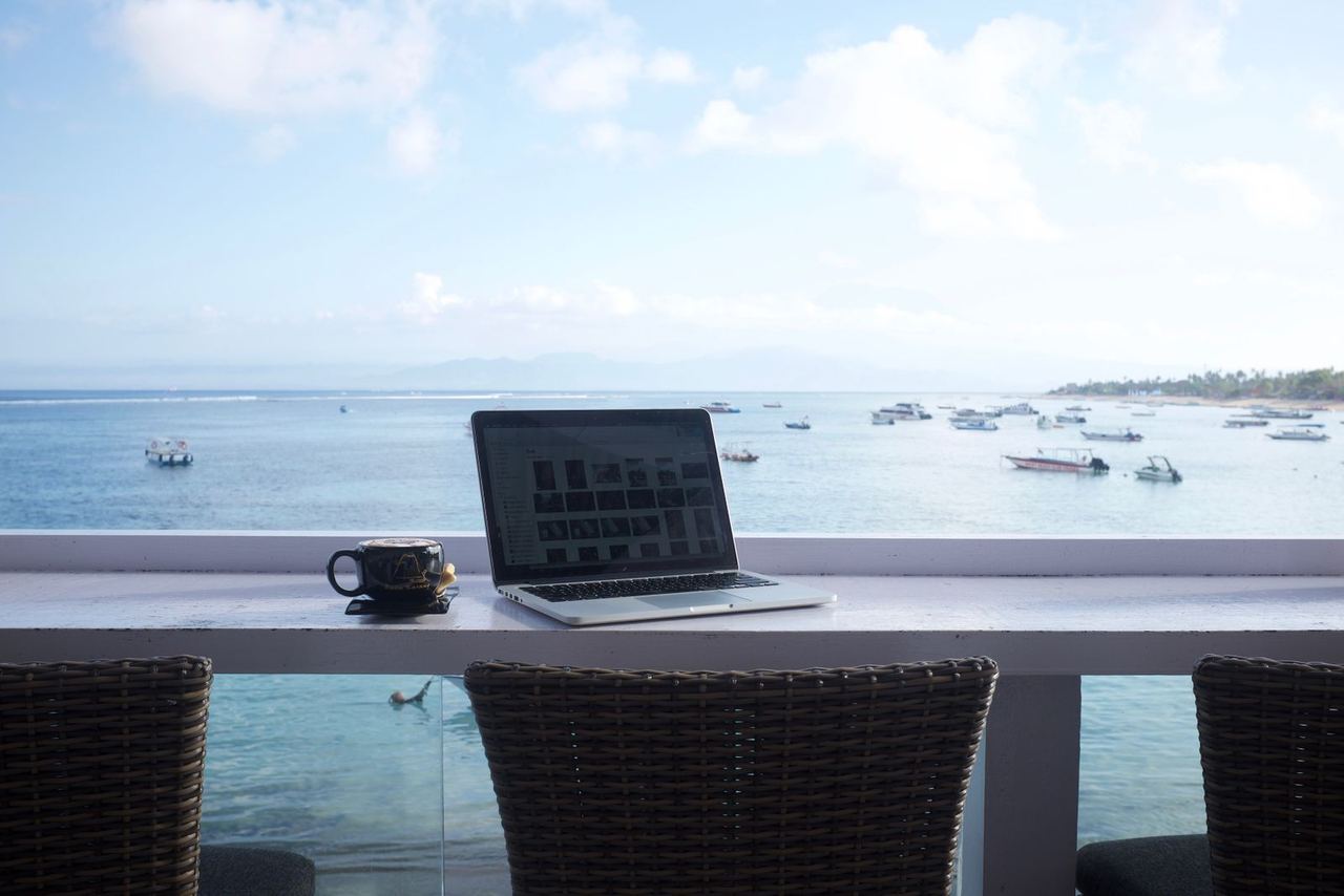 Illustrative photo: laptop workspace with a sea view
